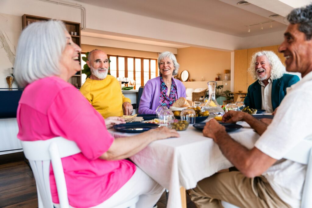 Group of senior friends bonding at home for dinner party