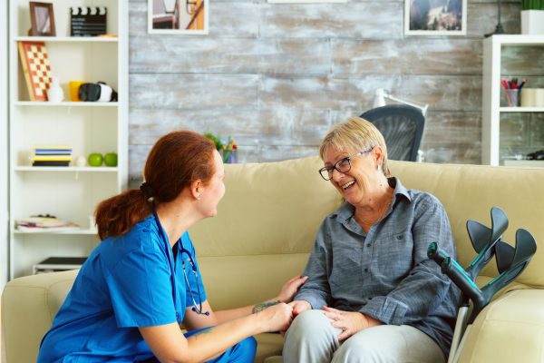 Female nurse talking with old woman with alzheimer